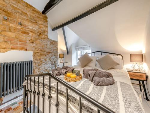 a bedroom with a bed with a basket on it at Patience Cottage in Idbury