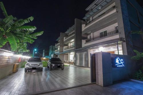 two cars parked outside of a building at night at Soar B&B in Taitung City