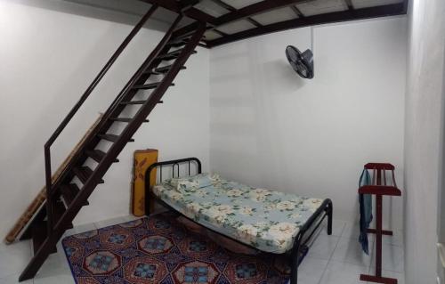 丹戎馬林的住宿－Homestay D'Mama Īfor mūslimĪ，客房设有双层床和楼梯。