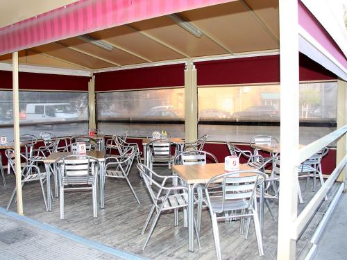 a restaurant with tables and chairs with a train in the background at Hostal Restaurante La Masía in Villareal