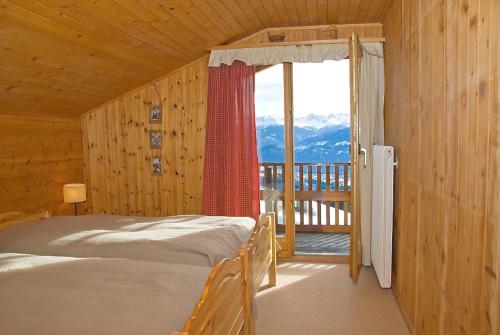 a bedroom with two beds and a balcony with a view at Outstanding chalet for groups, south facing, breathtaking views - all year round in Anzère