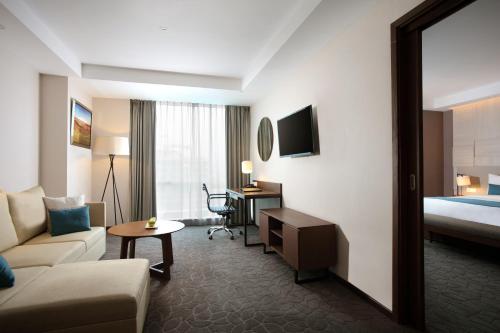 a hotel room with a couch and a bed at Crowne Plaza Bandung by IHG in Bandung