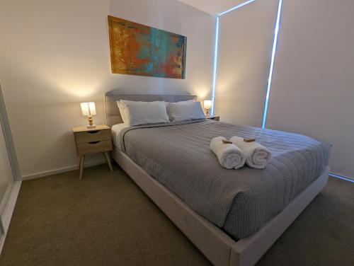 1 dormitorio con 1 cama con 2 toallas en Newcastle Harbourside Terraces, en Newcastle