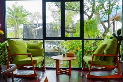 a room with chairs and a table and a window at Srihome ยายศรีโฮมแอนแคมป์ปิ้ง in Ban Don Tum (1)