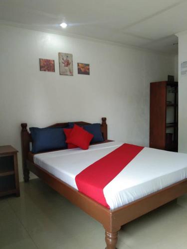 a bedroom with a large bed with red and blue pillows at PEDRO'S RESORT in Panglao Island