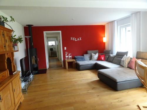 a living room with a couch and a red wall at Chasa Felix Scuol in Scuol