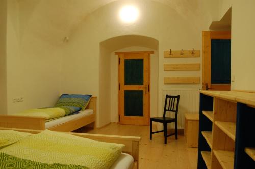 ein Schlafzimmer mit einem Bett und einem Stuhl darin in der Unterkunft Penzion Čáslava in Rokytno