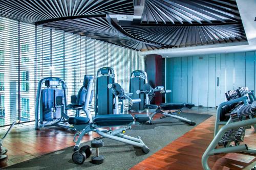 a gym with blue chairs and a large window at The Sakala Resort Bali All Suites in Nusa Dua