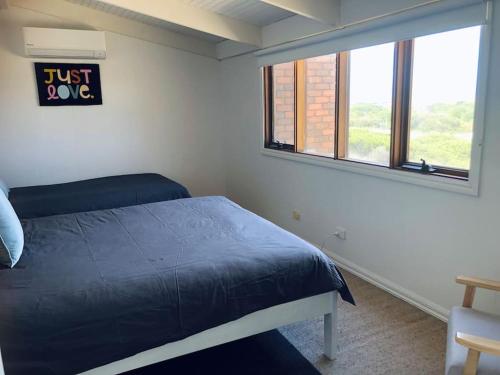 彼得伯勒Peterborough Beach House的一间卧室,卧室里配有一张床和一个只表示爱的标志