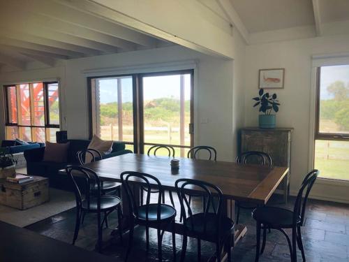 彼得伯勒Peterborough Beach House的配有木桌椅的餐厅