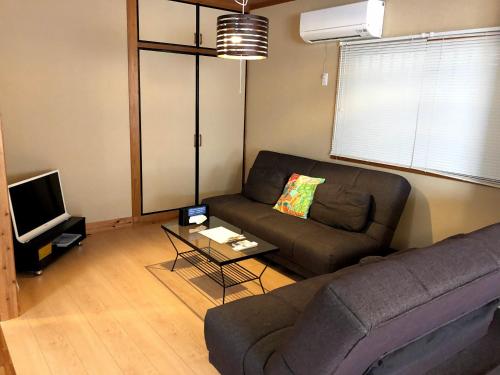 salon z kanapą i telewizorem w obiekcie Endless Summer Okinawa South w mieście Okinawa