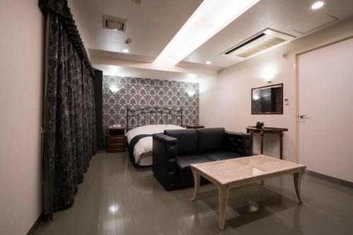 a living room with a couch and a bed at Hotel Rea Tiare - Adult Only- in Himeji