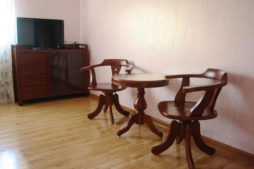 two chairs and a table and a tv in a room at Little Shangri-La in Almaty