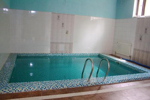 a swimming pool in a room with a tile wall at Little Shangri-La in Almaty