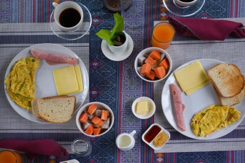 un tavolo con un piatto per la colazione con uova, formaggio e pane di Mandala Ou Resort a Nongkhiaw