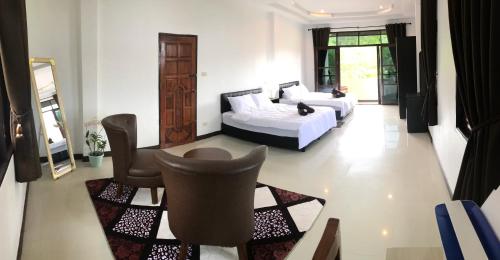 a bedroom with two beds and a table and chairs at Orchid Pool -Villa 3 bedrooms in Ko Lanta