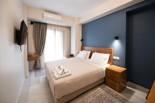 1 dormitorio con cama blanca y pared azul en Patras Casale en Patras