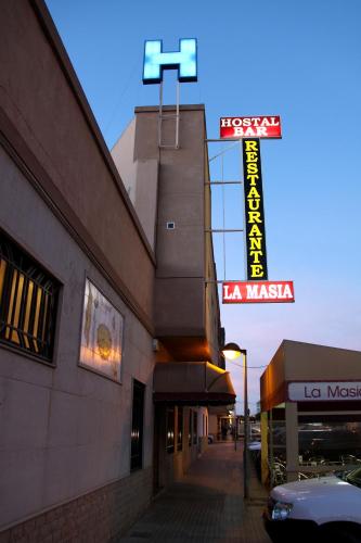 a building with a neon sign on the side of it at Hostal Restaurante La Masía in Villareal