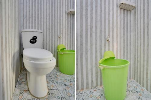 een badkamer met een toilet en 2 groene vuilnisbakken bij SPOT ON 91745 Rumah Kost Gresik Syariah in Gresik