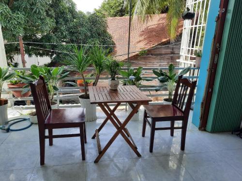 a wooden table and two chairs on a patio at Tai Tri Guest House in Phu Quoc