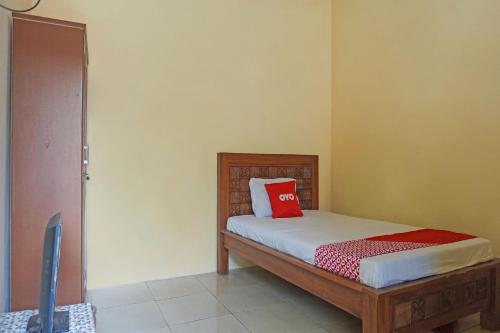 - une chambre avec un lit doté d'un oreiller rouge dans l'établissement OYO 91762 Green Home Stay Syariah, 