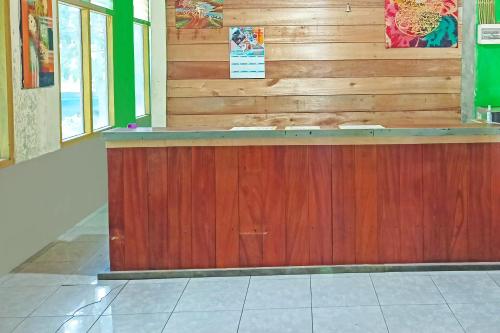 TanjungselorにあるOYO 91768 Hotel Tanjung Permaiの木製の壁の部屋のカウンター