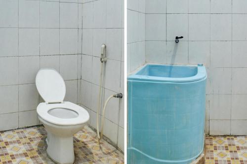 y baño con aseo y bañera azul. en OYO 91769 Wisma Harapan Baik en Kupang