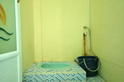 a small bathroom with a toilet with a bucket at SPOT ON 91791 Homestay Surya Syariah in Tarakan