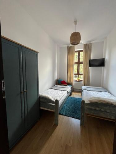 1 dormitorio con 2 camas individuales y ventana en Przy Poznańskiej Bramie, en Inowrocław