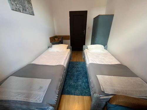 2 Betten in einem kleinen Zimmer mit einer Tür in der Unterkunft Przy Poznańskiej Bramie in Inowrocław