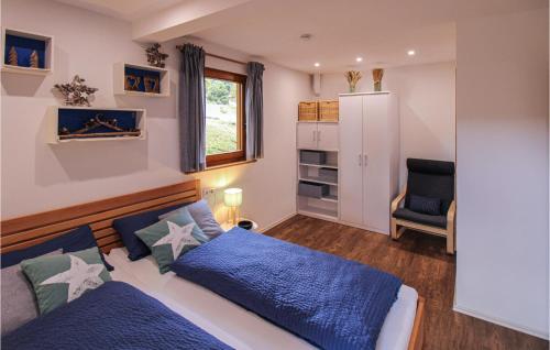 a bedroom with a blue bed and a chair at Chalet Bestaenderhof in Obertal