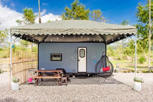 einem blauen Wohnwagen mit einem Zelt und einer Schaukel in der Unterkunft Geothermal Camper Van in Ta-hsi