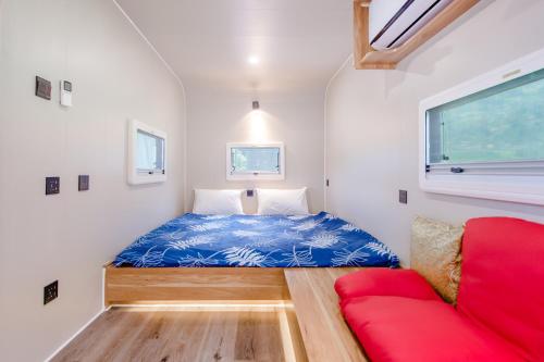 a small bedroom with a bed and a red couch at Tai  Ping  Shan Inn in Ta-hsi