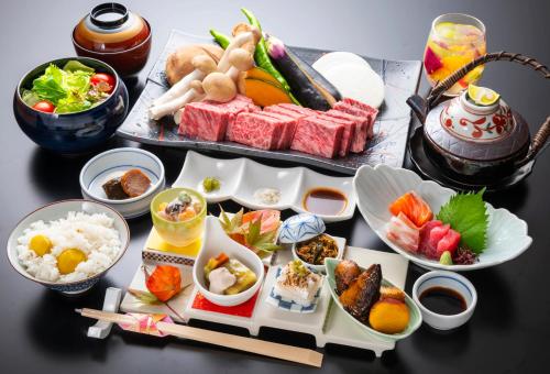 una mesa cubierta con platos de comida y tazones de comida en Yunotani Senkei en Totsukawa