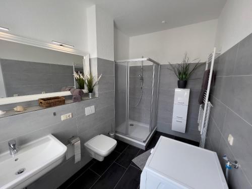 La salle de bains est pourvue d'un lavabo et d'une douche. dans l'établissement Cityapartments am Hafen, à Waren