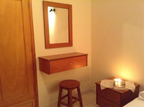 a bathroom with a vanity and a stool and a mirror at Menelaos Apartments in Lefokastro