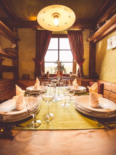 a table with wine glasses and plates on it at Penzion a Restaurace U Johana in Zlín