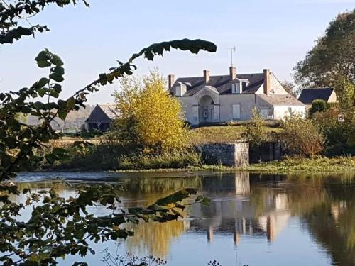 a house on a hill next to a body of water at Gite de la Salamandre aan de rivier de Cher vlakbij Zoo de Beauval in Thésée