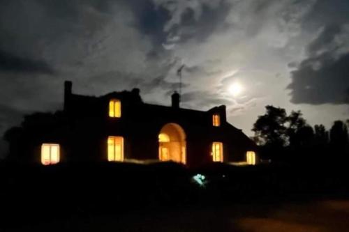 a house lit up at night with the moon behind it at Gite de la Salamandre aan de rivier de Cher vlakbij Zoo de Beauval in Thésée