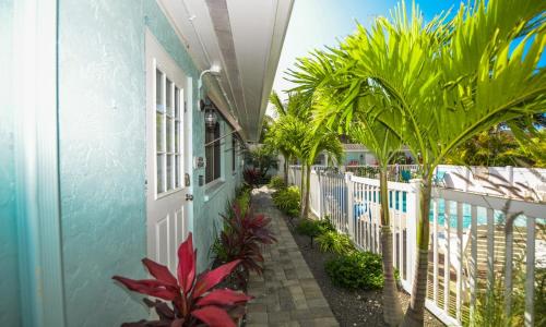 a hallway of a house with palm trees and a fence at Driftwood Villas at Anna Maria Island Inn in Holmes Beach
