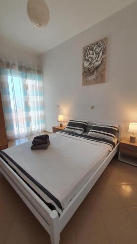 a large white bed in a room with two lamps at Blue Bay Apartment in Chania