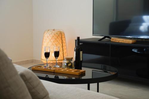 a table with two glasses of wine and a lamp at סיני 48 מלון דירות בוטיק in Vered Yeriho