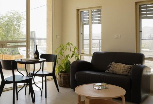 a living room with a couch and a table and chairs at סיני 48 מלון דירות בוטיק in Vered Yeriho