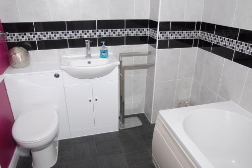 a bathroom with a white sink and a toilet at Seashells Cottage in Gorleston-on-Sea