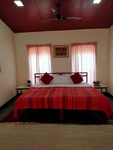 a bedroom with a large bed with a red blanket at Naurang Yatri Niwas in Garli