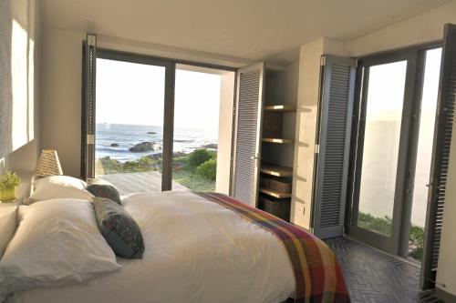 a bedroom with a bed with a view of the ocean at Sonkwas 10 in Paternoster