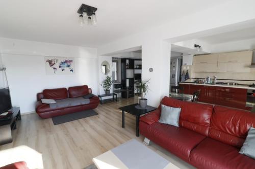 a living room with a red couch and a kitchen at Danielle Apartament in Iaşi