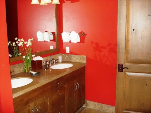 baño con 2 lavabos y pared roja en Teton Club, en Teton Village