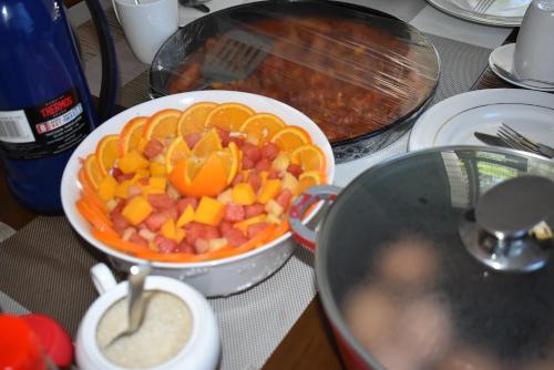 a table with a bowl of fruit and a bowl of dip at El Tessa garden/serviced apartment in Kisumu