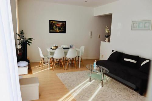 uma sala de estar com um sofá preto e uma mesa em 3C-Apartments em Gante